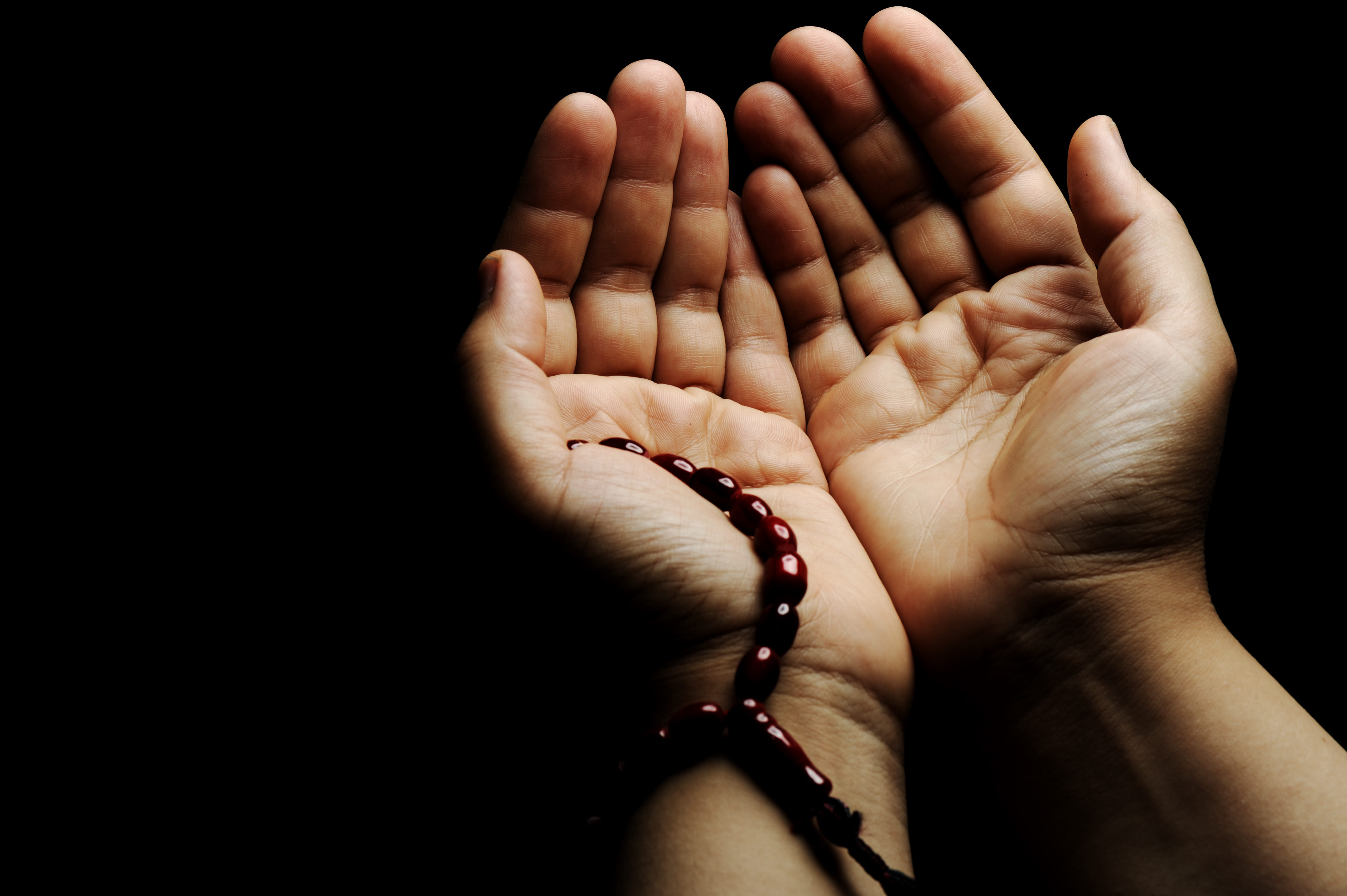 Hands holding prayer beads in a quiet spiritual moment